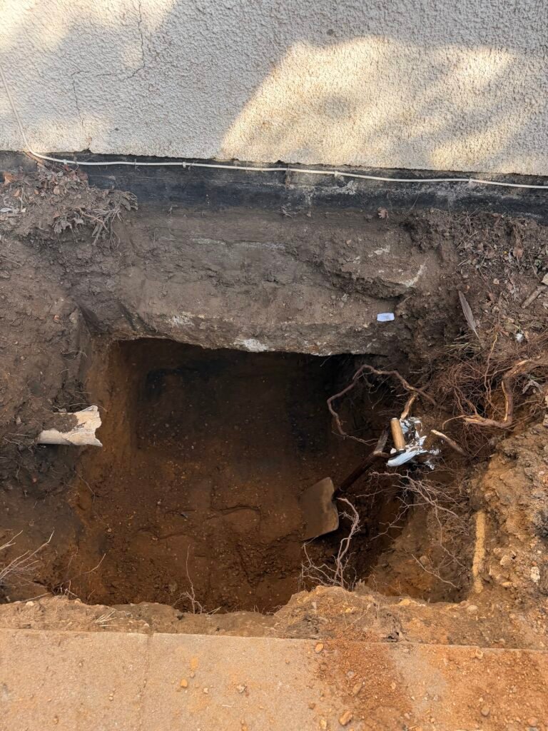 Foundation excavation and groundworks beside an existing property